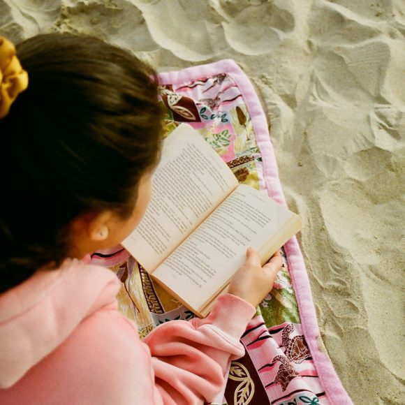 girl in pink hoodie reading book